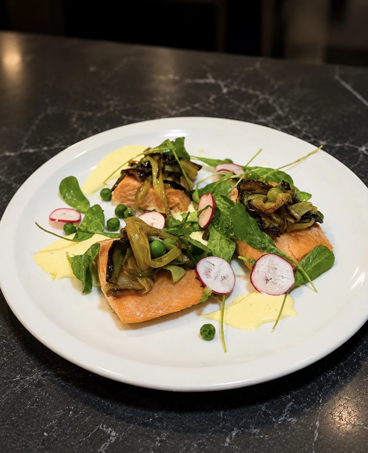 Salmón de Nocedal con arvejas, rábano y hierbas frescas