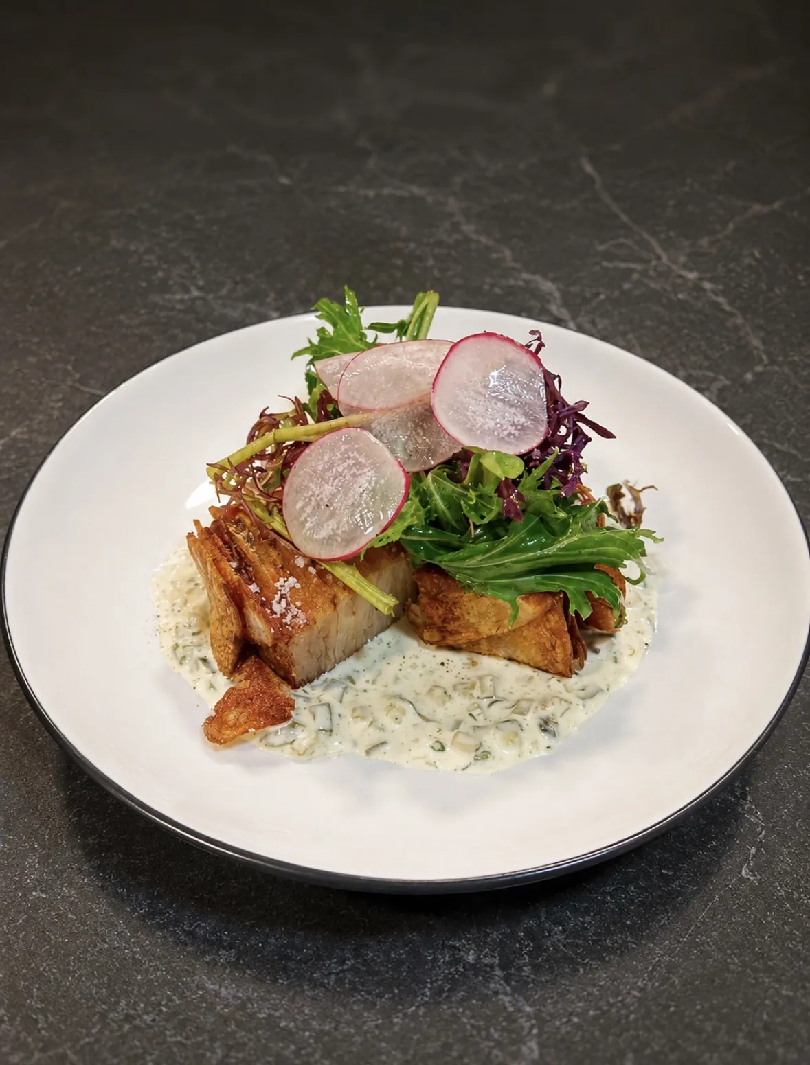 Plato de fondo de Nocedal con panceta crocante y ensalada de rábano